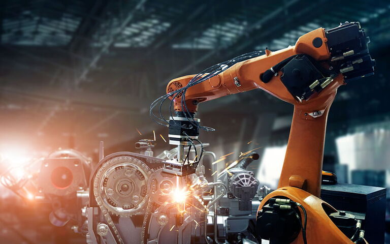 Roboterarm schweißt an einem Motor